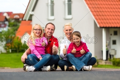 Family sitting in front of home