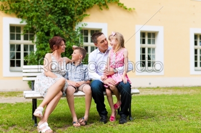 Family sitting in front of their home
