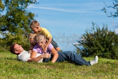 Family with children playing on a meadow