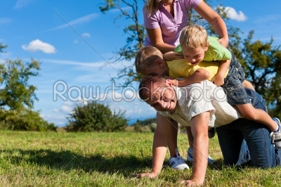 Family with children playing on a meadow