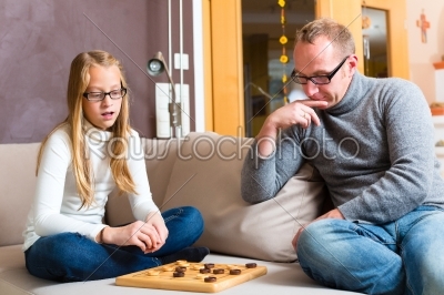Father and daughter playing checkers