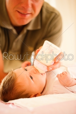 Father is feeding his baby with a bottle