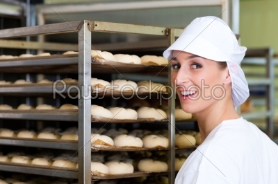Female baker baking bread rolls