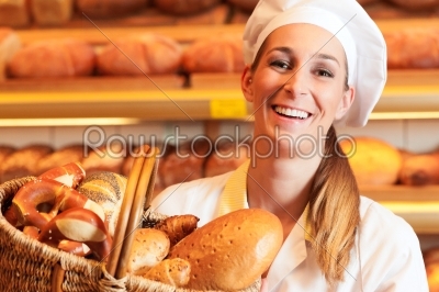 Female baker in bakery selling bread by basket 