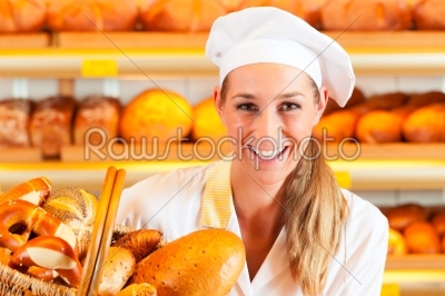 Female baker in bakery selling bread by basket 