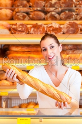 Female baker in her bakery with baguette