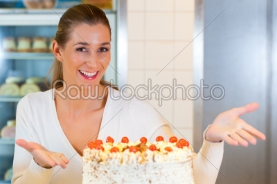 Female baker or pastry chef with torte