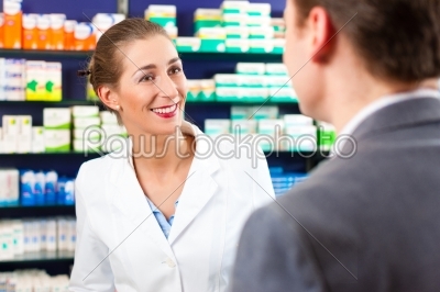Female pharmacist consulting a customer in pharmacy