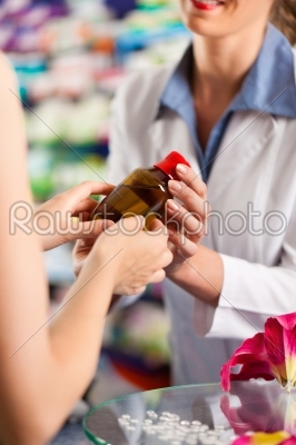 Female pharmacist in her pharmacy with a client