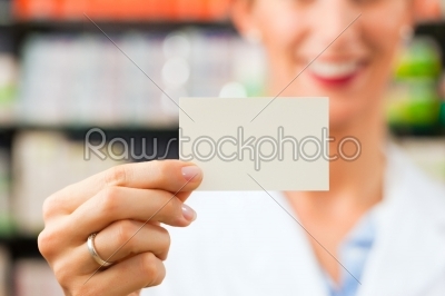 Female pharmacist with business card in pharmacy