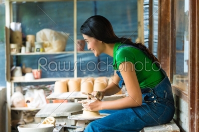 Female Potter creating a bowl on a Potters wheel