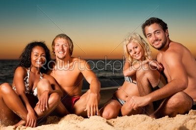 Four friends at sunset beach