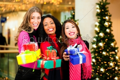 Friends Christmas shopping with presents in mall
