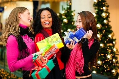 Friends Christmas shopping with presents in mall