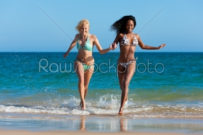 Friends running on beach vacation