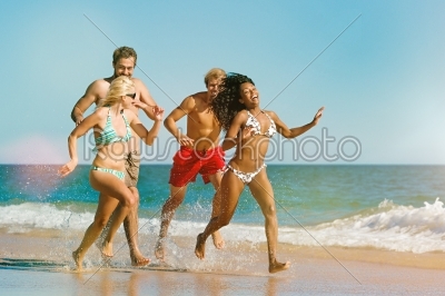 Friends running on beach vacation