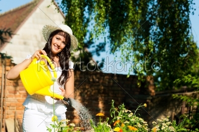 Gardening in summer - woman watering flowers