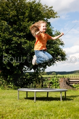 Girl child on trampoline in the garden