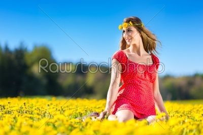 Girl in spring on a flower meadow with dandelion