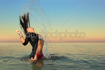 girl splashing the sea water with her hair