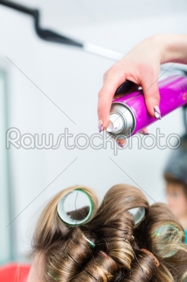 Hairdresser - hair stylist curling hairs