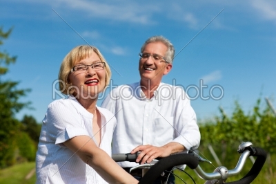 Happy couple cycling outdoors in summer