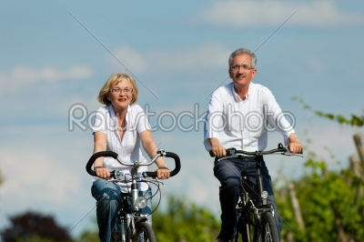 Happy couple cycling outdoors in summer
