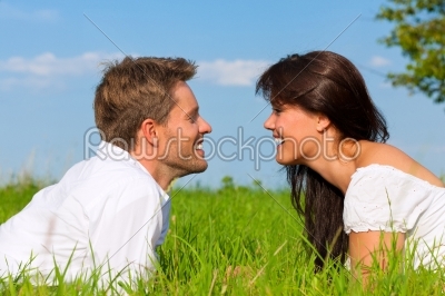 Happy couple lying on a meadow