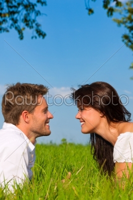 Happy couple lying on a meadow