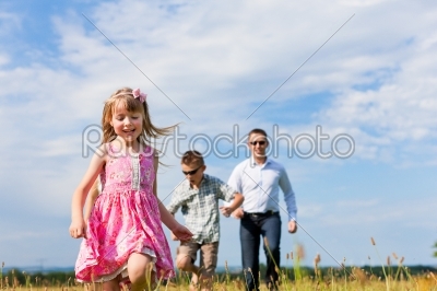 Happy family on a meadow in summer