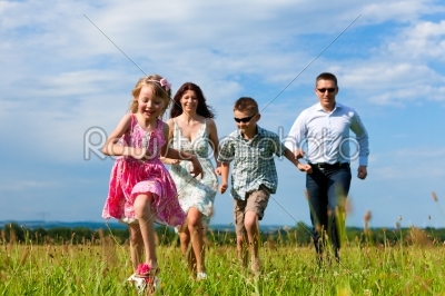 Happy family on a meadow in summer