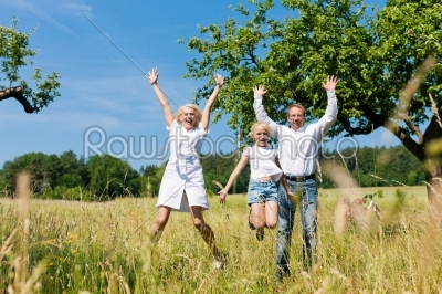 Happy family outdoors jumping