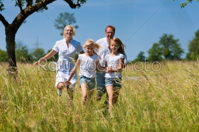 Happy family running in the meadow
