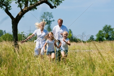 Happy family running in the meadow