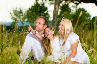 Happy family sitting in meadow