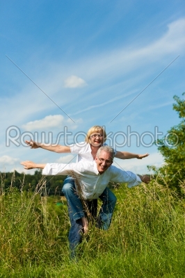 Happy senior couple having fun outdoors in summer