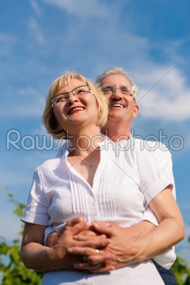 Happy senior couple looking to the blue sky