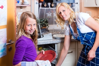 Housewife and daughter doing dishes with dishwasher
