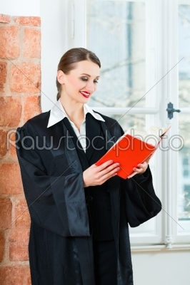 Lawyer in office reading law book