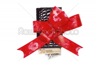 Leather female wallet with some euro inside wrapped in red bow