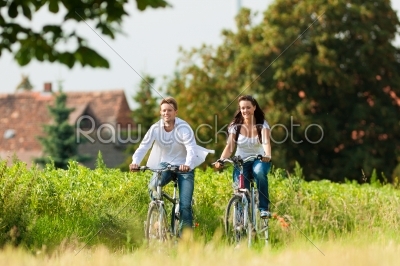 Man and woman cycling in summer