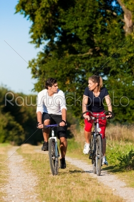 Man and woman exercising with bicycle