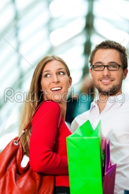 Man and woman in shopping mall with bags