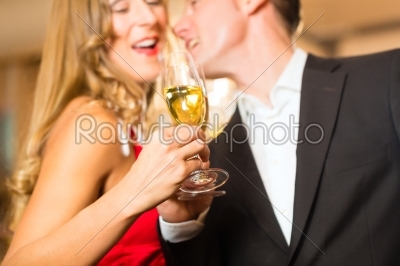 Man and woman tasting Champagne in restaurant