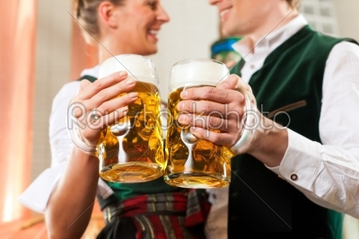Man and woman with beer glass in brewery