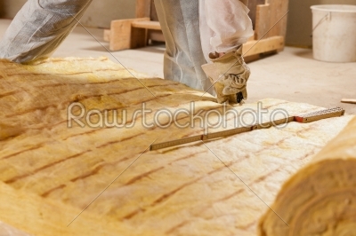 Man cutting insulation material for building