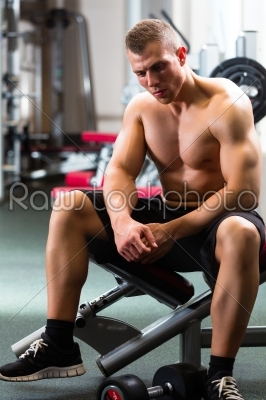 Man in gym or fitness studio on weight bench