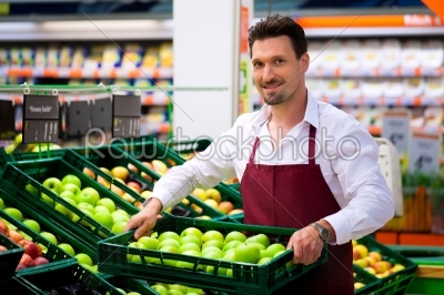Man in supermarket as shop assistant