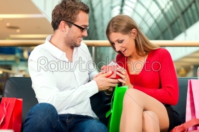 Man with gift for woman in mall