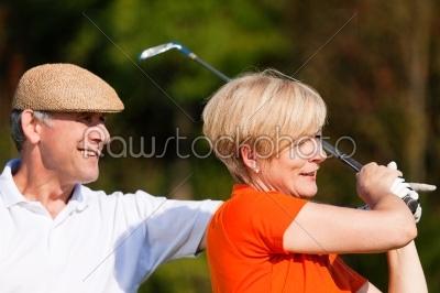 Mature couple playing golf